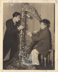 Salvador Dalí and Harpo Marx playing the harp at the artist's workshop.