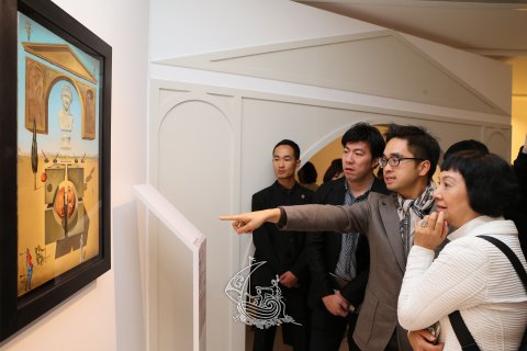 Adrian Cheng, fondateur et président honoraire de K11 Art Foundation montre un oeuvre de l'exposition aux visiteurs