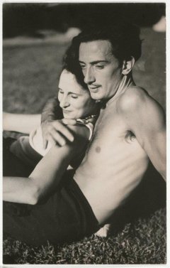 Una fotografia de Salvador Dalí amb Gala, tombats a la gespa en actitud afectuosa