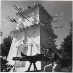 Picture of Salvador Dali under the tower of the House-Museum of Portlligat. It is a black and white picture.