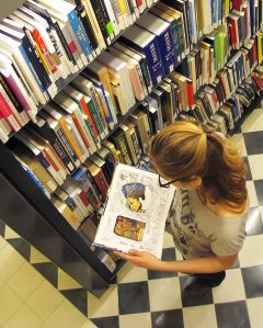 Una noia al Centre d’Estudis Dalinians observa un llibre obert que té a les mans. 