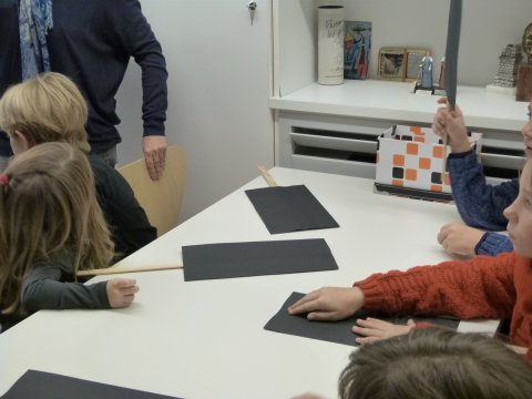 Une mince baguette de bois d'environ 60 cm et un papier cartonné